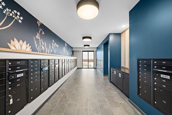 A hallway with mailboxes on the side and a flower painted on the wall at The Landing at Amber Fields Apartments, Minnesota